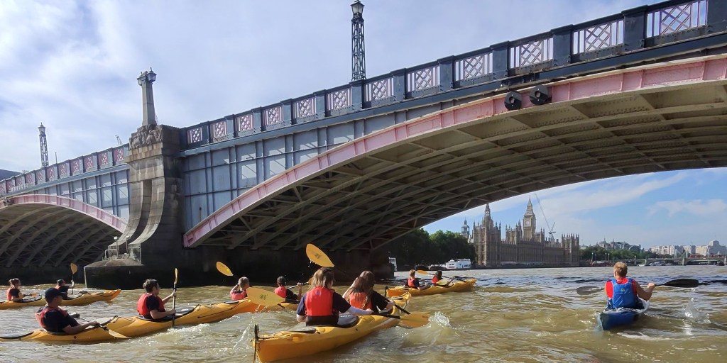 Sea Scouts in kayaks paddling on the River Thames in England